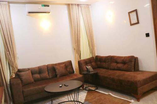 a living room with a couch and a table at See2ru Burj Apartment and Lounge in Abuja