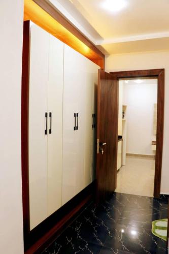 a hallway with white cabinets and a door to a bathroom at See2ru Burj Apartment and Lounge in Abuja