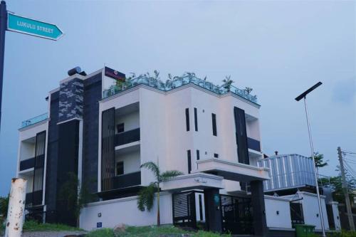 a white building with a street sign in front of it at See2ru Burj Apartment and Lounge in Abuja