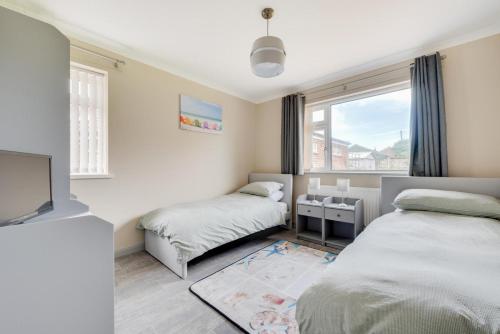 Un dormitorio pequeño con dos camas y una ventana. en LAmourette, en Bacton