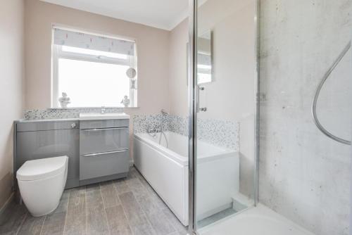 Un baño con bañera, inodoro y ducha. en LAmourette, en Bacton