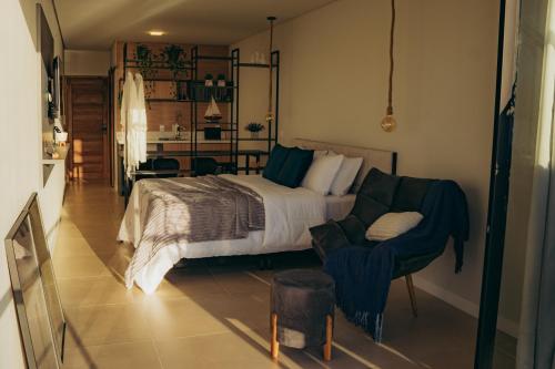 a bedroom with a bed and a chair at Austral Suítes à Beira-Mar in Imbituba
