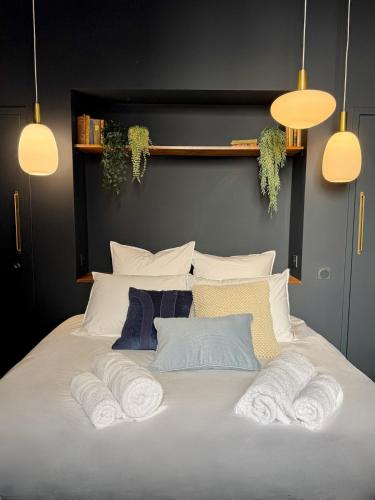 a white bed with three towels on top of it at Suite Romantique, hyper centre in Caen