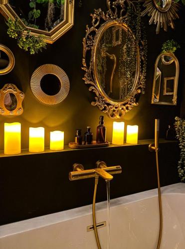 a bathroom with a tub and a mirror and lights at Suite Romantique, hyper centre in Caen