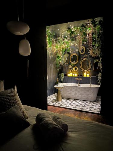 a bedroom with a bathroom with a tub and a sink at Suite Romantique, hyper centre in Caen