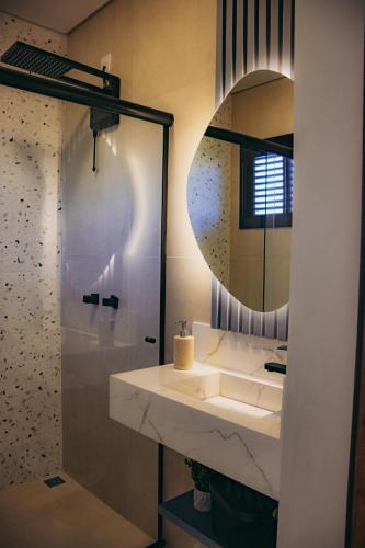 a bathroom with a sink and a mirror at Austral Suítes à Beira-Mar in Imbituba