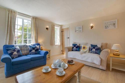 ein Wohnzimmer mit blauen Sofas und einem Couchtisch in der Unterkunft Town Yard Cottage in Cley next the Sea