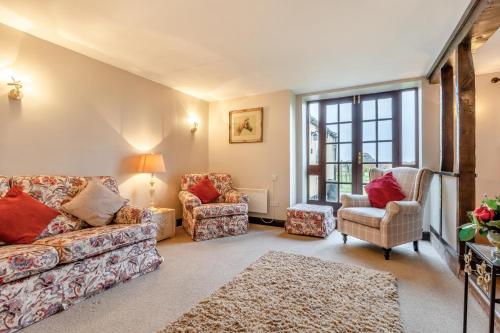a living room with a couch and two chairs at Grange Farm House in Hainford
