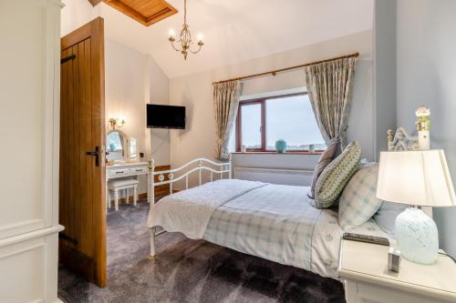 a bedroom with a bed and a desk and a window at Grange Farm House in Hainford