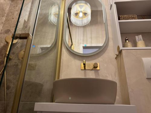 ヴコヴァルにあるBelvedere Studio Apartmanのバスルーム(椅子、鏡付)