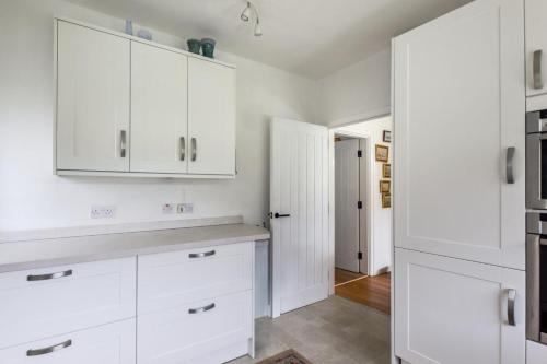 eine weiße Küche mit weißen Schränken und einer Theke in der Unterkunft Sandy Dell in Beadnell