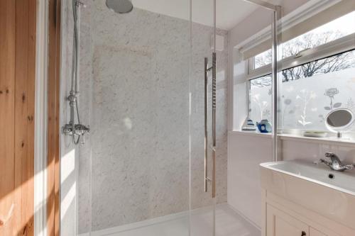 a bathroom with a shower and a sink at Poppy Cottage in Briston