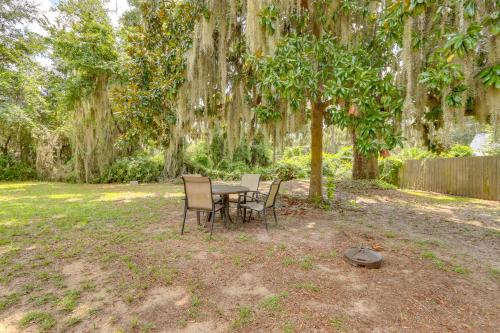 a table and chairs under a tree in a yard at 1 Mi to Sands Beach Walkable Island Home with Yard! in Port Royal
