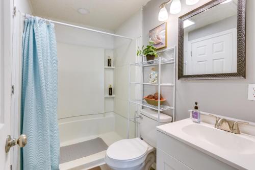 a bathroom with a toilet and a sink and a mirror at Beachy Home in Heart of Beaufort with Pool Access in Beaufort
