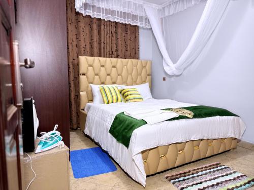 a bedroom with a large bed with green and white at Sunbeam Homes Kampala in Kampala