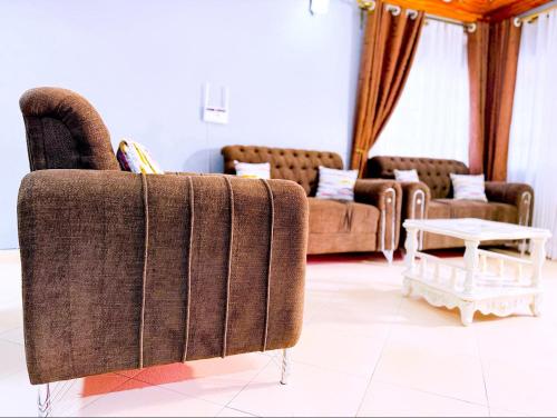 a living room with two couches and a table at Sunbeam Homes Kampala in Kampala