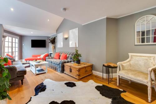 a living room with a couch and chairs at Ivy Lodge in Rendlesham
