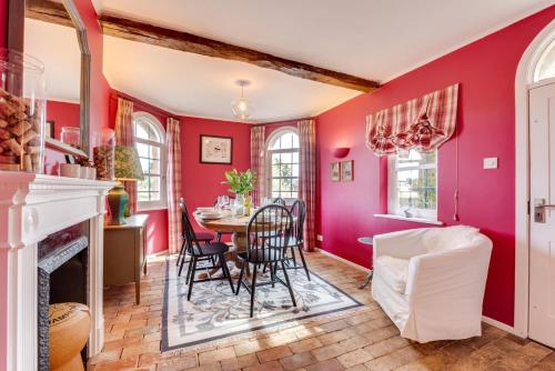 a dining room with red walls and a table and chairs at Ivy Lodge in Rendlesham