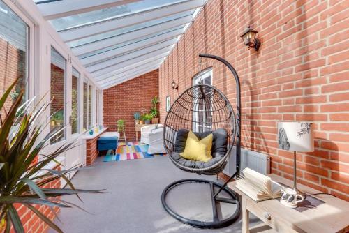 a porch with a bird cage sitting on a brick wall at Ivy Lodge in Rendlesham