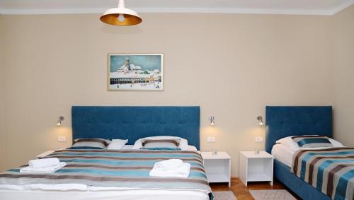 two beds in a room with blue headboards at Apartments & Rooms Flowers in Zagreb