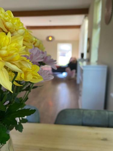 a vase of yellow flowers sitting on a table at Gastvrij genieten in Emmen