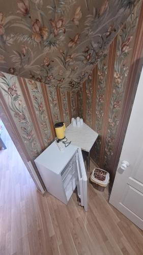 a room with a table and a ceiling with flowers at Guest House Krista in Jūrmala