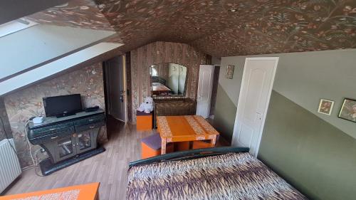 a room with a living room with a table and a television at Guest House Krista in Jūrmala