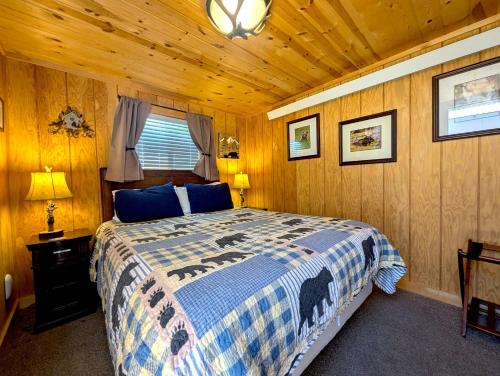 a bedroom with a bed in a wooden room at Yellowstone's Treasure Cabins in Gardiner