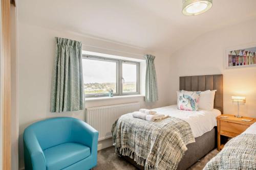 une chambre avec un lit et une chaise bleue dans l'établissement Beeston Sea View, à Sheringham