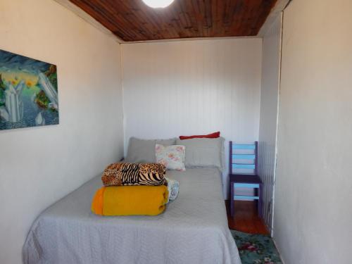 a small bedroom with a bed with a blue chair at Suíte vista maravilhosa in Ouro Preto