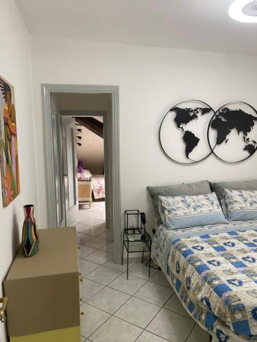 a bedroom with a bed and two clocks on the wall at Appartamento Lella Acqui terme zona corso bagni in Acqui Terme