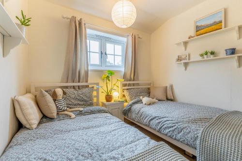 a bedroom with two beds and a stuffed dog sitting on the bed at Stone Cottages - Bodham in Bodham
