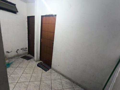 a bathroom with two doors and a tiled floor at ADE Coj 23 LT 4 Ap102 in Brasília