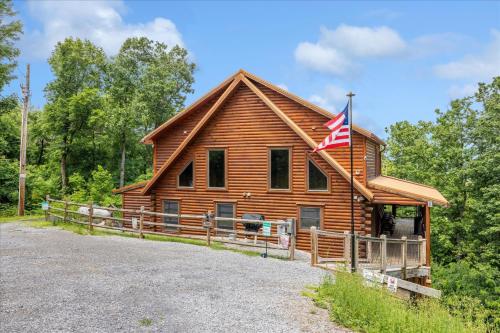 a log cabin with an american flag on it at Climbing to New Heights cabin in Cartertown