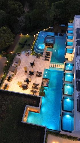 an overhead view of a building with a pool at night at Collegare Hotel in Capitólio