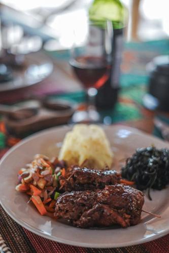 a plate of food with meat and vegetables on a table at Angalia Tented Camp in Mikumi