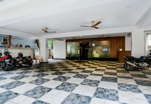 a room with motorcycles parked on a checkered floor at Super Hotel O Gokul Grand Near SR Nagar Police Station in Hyderabad