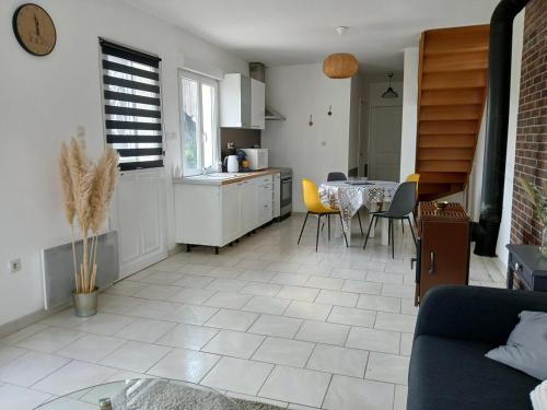 a kitchen and living room with a table and chairs at La maison du verger in Magny-Fouchard