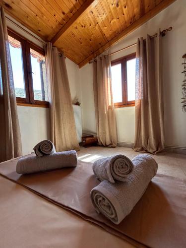 two rolled towels sitting on the floor in a room with windows at Ziras Traditional Villa in Áno Váthia