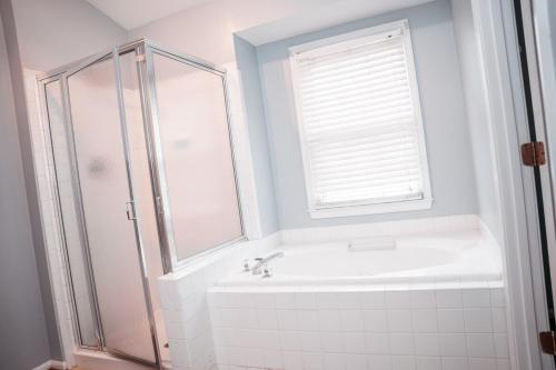a bathroom with a shower and a tub and a sink at Cozy Stay Springfield Townhome in Springfield