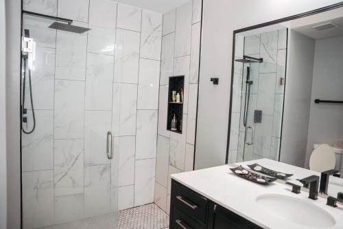a white bathroom with a shower and a sink at Cozy Stay Springfield Townhome in Springfield