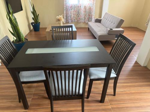 a black dining room table with chairs and a couch at Vacation Rental in Paix Bouche