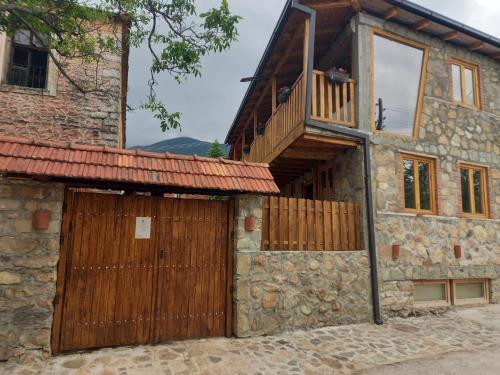an old stone house with a wooden door and a balcony at Villa Old House BN in Bitola
