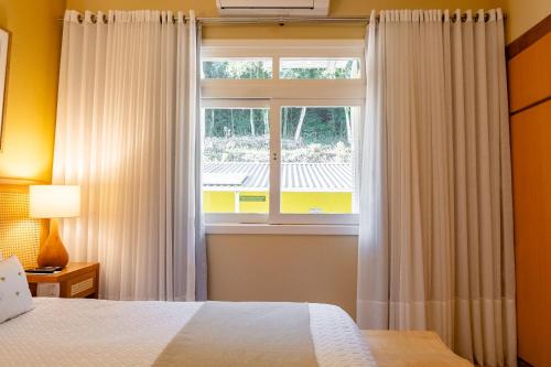 a bedroom with a bed and a window at Hotel Pousada da Neve in Nova Petrópolis