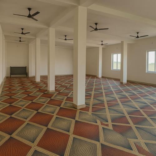 an empty room with two ceiling fans at Shree Venkateshwar dham Atithi bhawan in Naimishāranya