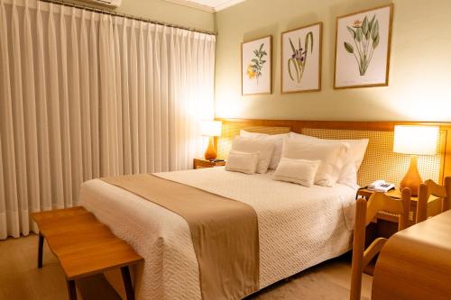 a hotel room with a bed and two lamps at Hotel Pousada da Neve in Nova Petrópolis