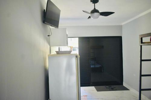 a kitchen with a refrigerator and a ceiling fan at Residencial Solar do Pescador in São Sebastião