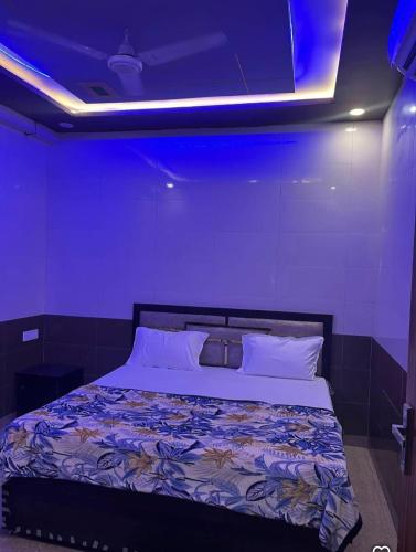 a bedroom with a large bed with a blue ceiling at Chaudhary Home Stay in Mathura