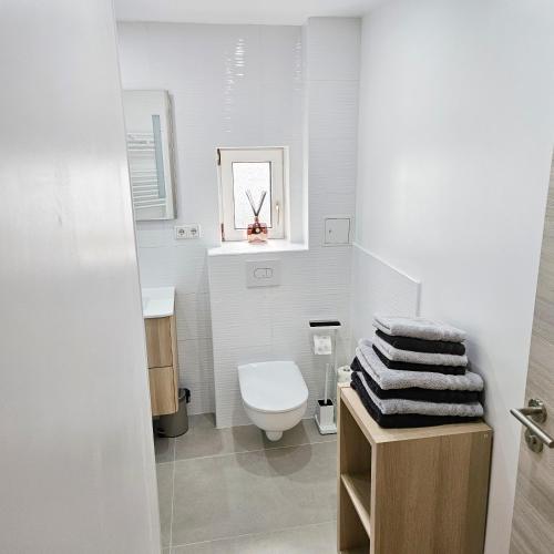 ein weißes Badezimmer mit Toilette und Waschbecken in der Unterkunft Ferienwohnung Popp Langen in Langen