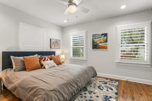 una camera da letto con un letto grande con due finestre di Pool House Oasis - Home for 6 a Tampa